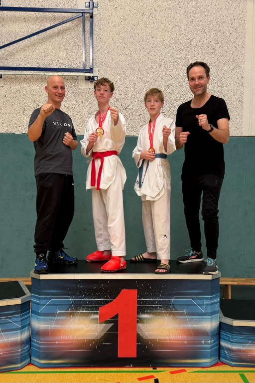 Jesaja Gotwalt en Reinier Essers op de 1ste plaats van het erepodium vergezeld door hun coaches.